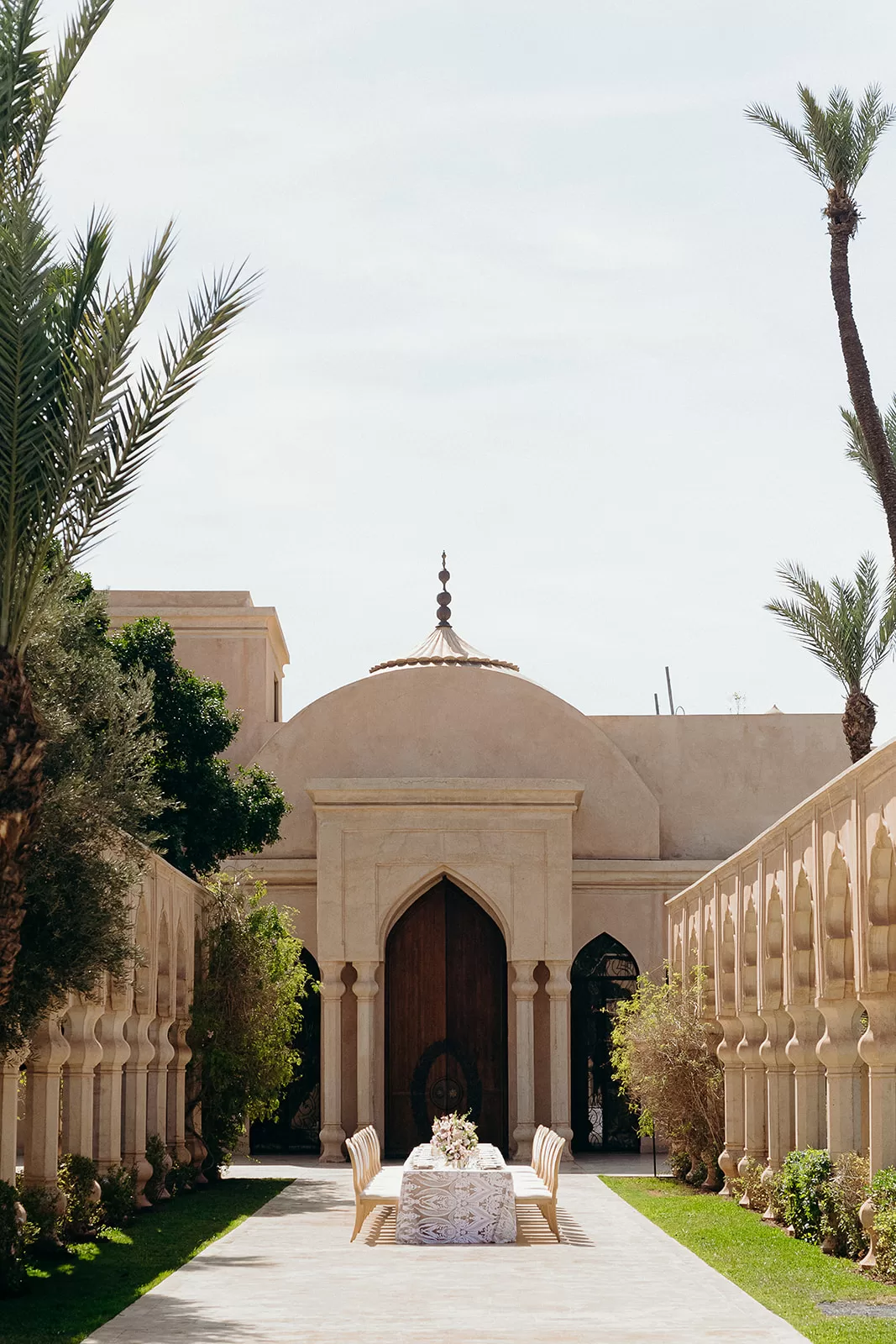 Symmetrical courtyard ceremony setup with long table and arched architecture at Palais Namaskar