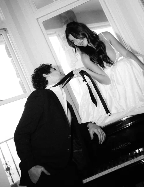 A playful black and white portrait with the bride holding the groom’s tie.