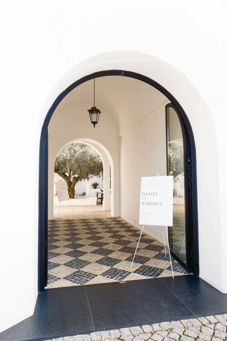 Elegant arched entrance at Quinta Dos Santos with minimalist wedding signage and tiled flooring.