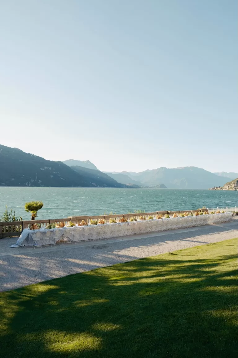 Wide view of an elegant lakeside banquet table set along the terrace at Villa Lario Resort