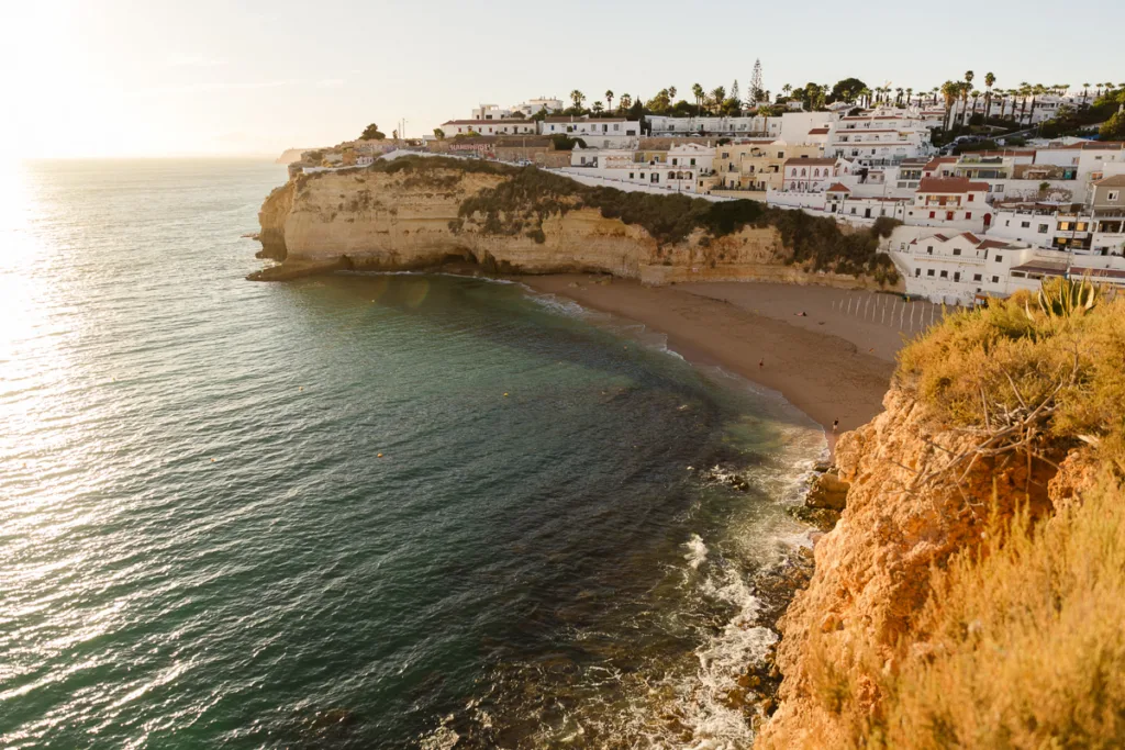 View across the Algarve coastline with golden cliffs, beach and calm sea at sunset