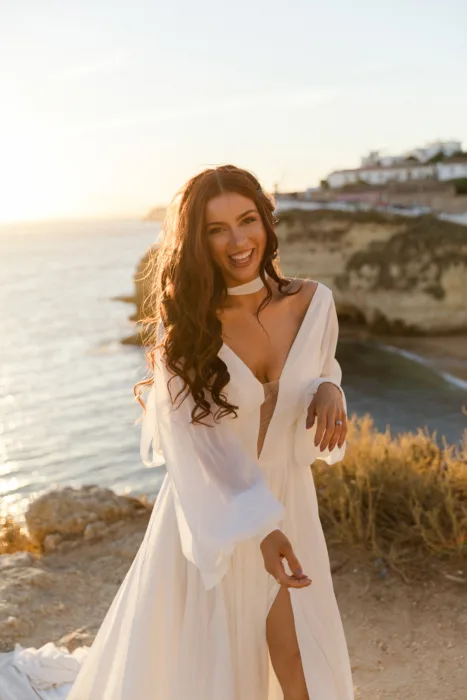 Bridal portrait overlooking the Algarve cliffs and sea during golden hour