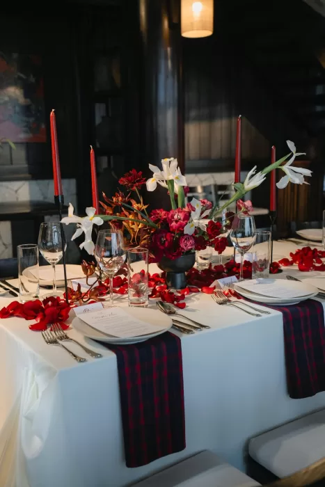 Red candles and white iris flowers bring dramatic colour to the reception table.