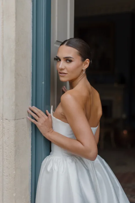 Bride looking back over her shoulder while standing in the doorway of a country house wedding venue