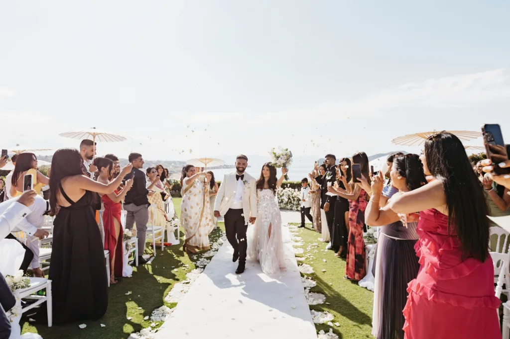Couple walks through confetti as guests celebrate at Sea View by En Kipo.