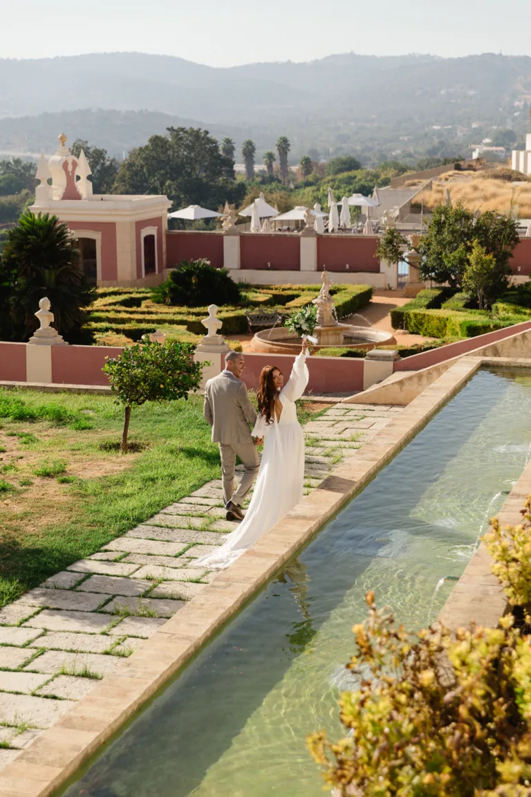Newlyweds walking through the gardens at Pousada Palácio Estoi after their ceremony