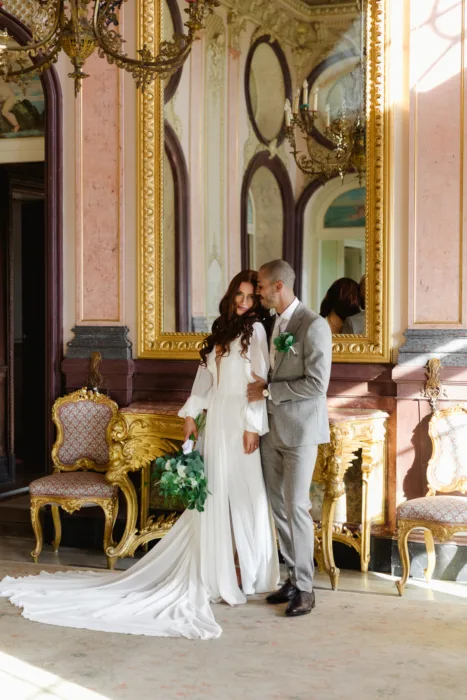 Bride and groom posing inside the ornate historic interiors of Pousada Palácio Estoi