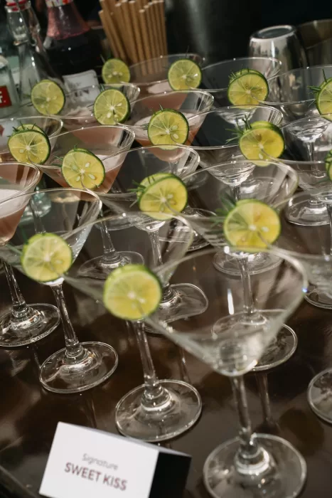 Coupe glasses with lime-garnished signature cocktails waiting for guests before the celebration.