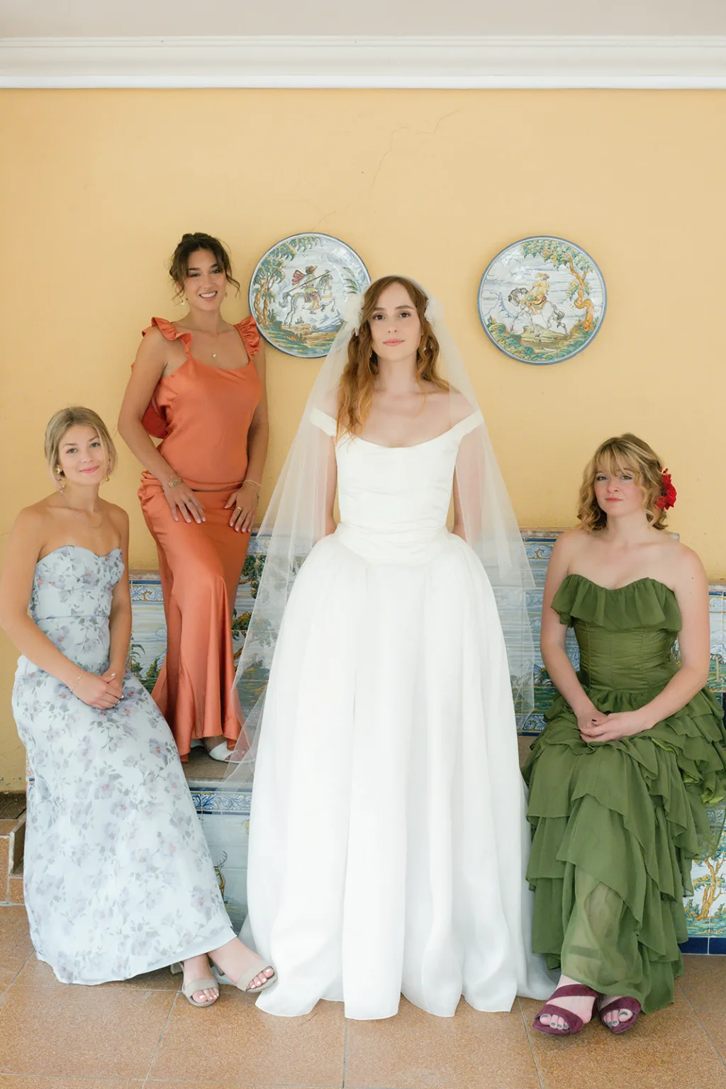 Bride with bridesmaids in colourful dresses posing indoors at Finca Morneta
